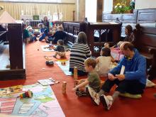 Parents and children sit on the floor and play